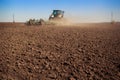 tractor cultivator raises great dust on soil