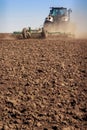 tractor cultivator raises great dust on soil