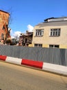 a tractor destroys a building behind a fence