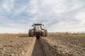 Tractor with double wheeled ditcher digging drainage canal