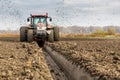 Tractor with double wheeled ditcher digging drainage canal