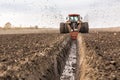 Tractor with double wheeled ditcher digging drainage canal