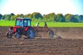 tractor drivers plow a field with a tractor. people work on a tractor seeder.