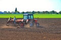 tractor drivers plow a field with a tractor. people work on a tractor seeder.