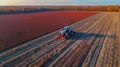 Tractor drives across large field for sowing seeds, drone view created with generative AI technology Royalty Free Stock Photo