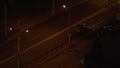 Tractor drives on empty city road at night. Roadbed is illuminated lanterns.