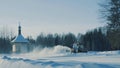 Tractor driving backwards and removing snow from the road