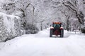 Tractor driving down a snow covered road Royalty Free Stock Photo