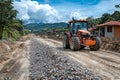 Tractor driving on a muddy road construction site, with piles of rocks and debris Royalty Free Stock Photo