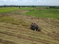 Tractor driving over rice field on harvest