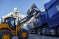 Tractor dumping quantities of grain into the back of a articulated lorry