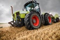 tractor equipped with a baler picking up the straw to make large rectangular bales before the rain