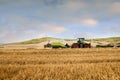 tractor equipped with a baler picking up the straw to make large rectangular bales before the rain