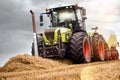 tractor equipped with a baler picking up the straw to make large rectangular bales before the rain