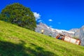 Tractor and farmers collects dry hay on the steep slope