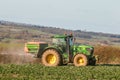 Tractor and fertilizer spreader in field