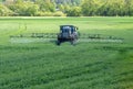 Tractor fertilizes a green field