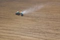 Tractor fertilizing field, Aerial View. Tractor spreading artificial fertilizers.