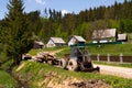 Tractor with firewood on landscape with green trees in countryside Royalty Free Stock Photo