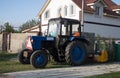 Tractor on the front lawn. Blue agricultural tractor for cultivating the land