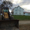 Tractor in front of an old house Royalty Free Stock Photo