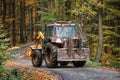 Tractor with grapple on road in forest. Lumber industry