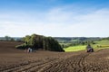 Tractor with harrow on field in beautiful countryside of south limburg in the netherlands on sunny day in the fall Royalty Free Stock Photo