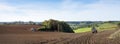 Tractor with harrow on field in beautiful countryside of south limburg in the netherlands on sunny day in the fall Royalty Free Stock Photo