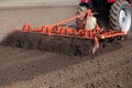 Tractor harrowing soil in spring