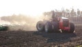 Tractor harvesting and soil cultivation for subsequent sowing. Field and dust in the sun, work in agriculture Royalty Free Stock Photo