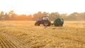 Tractor with hay bale making machine.