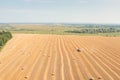 Tractor with Hay Baler works on yellow field collected hay bales. Royalty Free Stock Photo