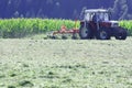 Tractor with hay tedder working on a mountain field Royalty Free Stock Photo