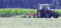 Tractor with hay tedder working on a mountain field Royalty Free Stock Photo