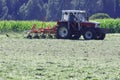 Tractor with hay tedder working on a mountain field Royalty Free Stock Photo