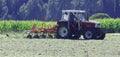 Tractor with hay tedder working on a mountain field Royalty Free Stock Photo