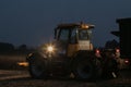 Tractor with headlights on at night time