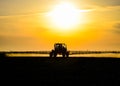 tractor with the help of a sprayer sprays liquid fertilizers on young wheat in the field Royalty Free Stock Photo