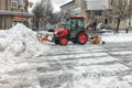 Tractor KIOTI CK 4020 with a bulldozer and a rotary brush clears snow