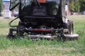 Tractor lawn mower mowing grass in park closeup Royalty Free Stock Photo