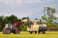 Tractor lifting hay bale on barrow Royalty Free Stock Photo