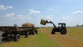 Tractor lifting hay bale Royalty Free Stock Photo