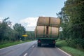 Tractor loaded with several straw bales drives over a country road