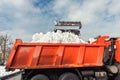 Tractor loader machine uploading dirty snow into dump truck. Cleaning city street, removing snow and ice after heavy Royalty Free Stock Photo