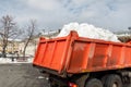 Tractor loader machine uploading dirty snow into dump truck. Cleaning city street, removing snow and ice after heavy Royalty Free Stock Photo
