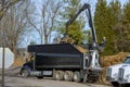 tractor loading mulch on truck