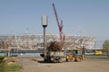 Tractor loads dry branches in the truck on the background construction of a new football stadium `Volgograd-Arena` for the world C