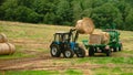 tractor loads round bales of straw on the trailer Royalty Free Stock Photo