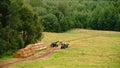 tractor loads round bales of straw on the trailer Royalty Free Stock Photo