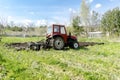 Tractor machinery plowing agricultural field meadow at farm at spring autumn.Farmer cultivating make soil tillage before